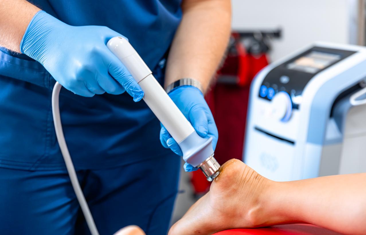 A technician using the phonophoresis method to aid in the treatment of someone's injured heel.