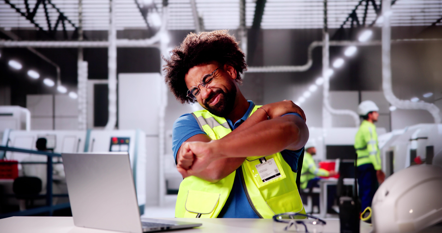 Man Doing Stretch Exercise At Automated Factory Or Plant